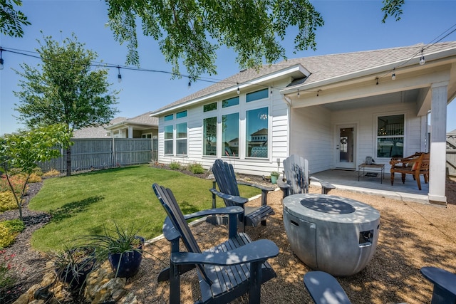 rear view of house with a yard, a patio area, a shingled roof, and fence private yard