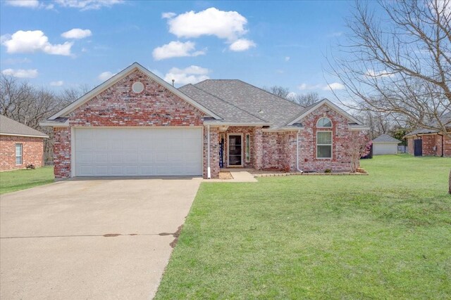 single story home with roof with shingles, a front lawn, concrete driveway, brick siding, and a garage