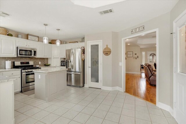 kitchen with white cabinets, decorative backsplash, visible vents, and appliances with stainless steel finishes