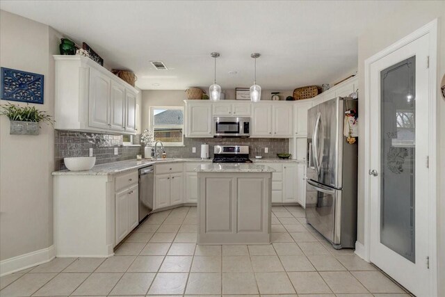 kitchen featuring stainless steel appliances, a sink, visible vents, backsplash, and white cabinetry