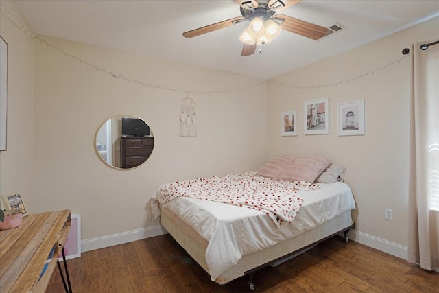 bedroom featuring baseboards, wood finished floors, and ceiling fan