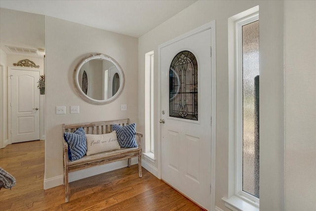 entrance foyer featuring baseboards, wood finished floors, visible vents, and plenty of natural light