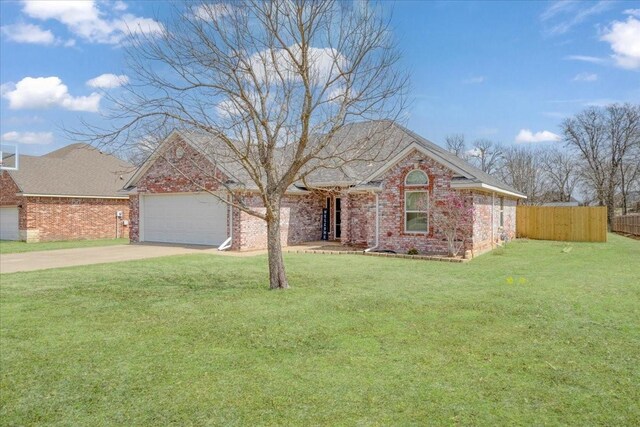 single story home with brick siding, fence, driveway, and a garage