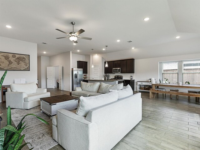 living area featuring recessed lighting, light wood-type flooring, visible vents, and a ceiling fan