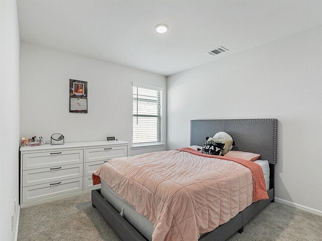 bedroom featuring light carpet, visible vents, and baseboards