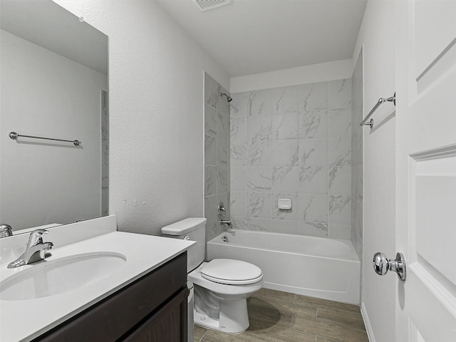 bathroom with wood finished floors, vanity, bathtub / shower combination, toilet, and visible vents
