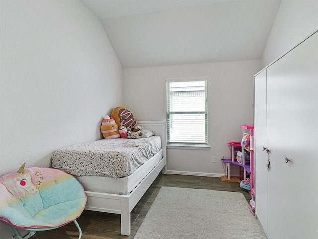 bedroom featuring baseboards, vaulted ceiling, and wood finished floors