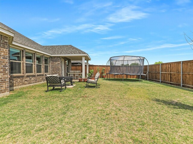 view of yard featuring a fenced backyard and a trampoline