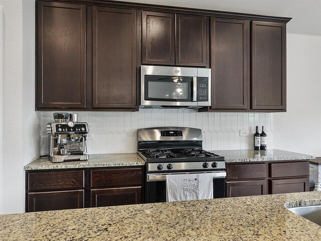 kitchen with dark brown cabinetry, backsplash, and appliances with stainless steel finishes
