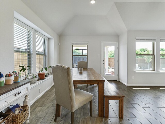 dining space with vaulted ceiling, baseboards, and dark wood-style flooring
