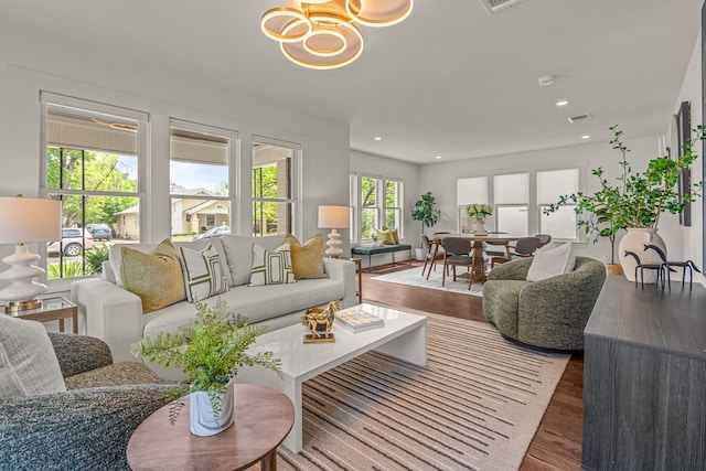 living room featuring an inviting chandelier, wood finished floors, visible vents, and recessed lighting