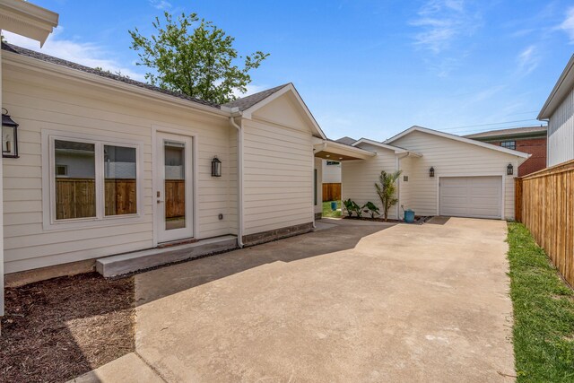 view of front of house featuring a garage, concrete driveway, and fence