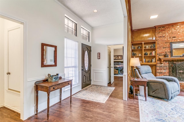 entrance foyer featuring wood finished floors, a wealth of natural light, a textured ceiling, and a decorative wall