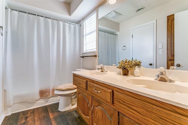 full bathroom with wood finished floors, a sink, and visible vents