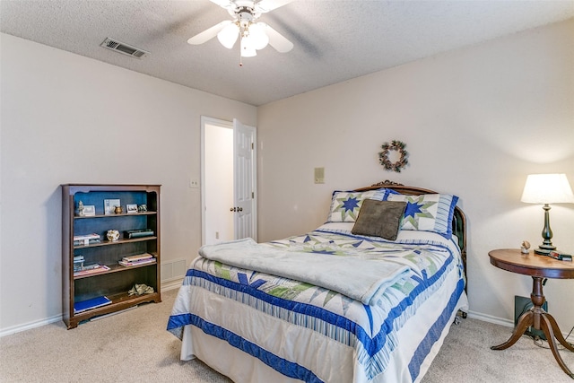 carpeted bedroom with baseboards, a textured ceiling, and visible vents