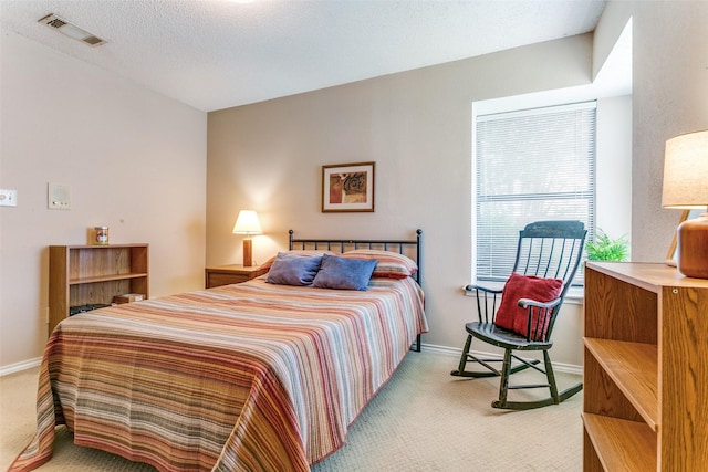 bedroom featuring baseboards, visible vents, and light colored carpet