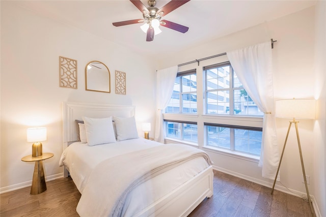 bedroom featuring dark wood-style flooring, baseboards, and ceiling fan