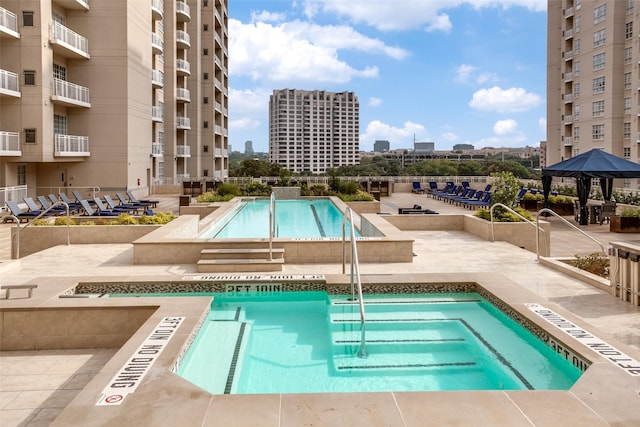 community pool with a city view and a patio