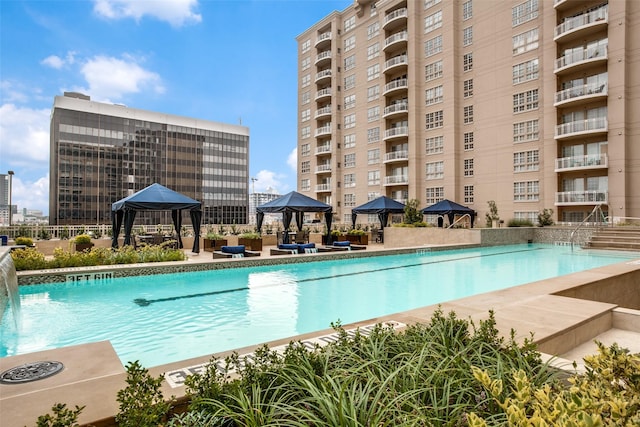 community pool with a gazebo, an outdoor living space, and a patio