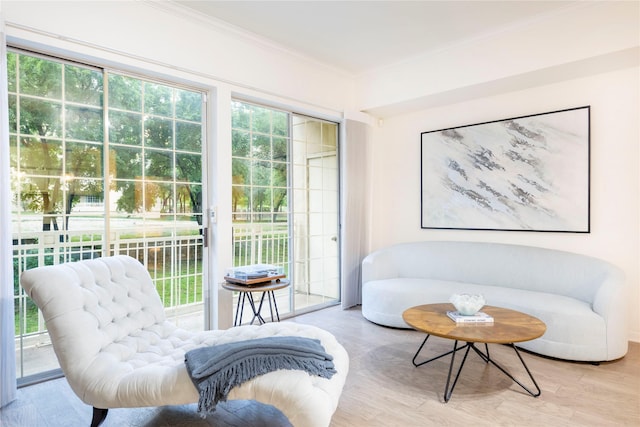 sitting room featuring ornamental molding and wood finished floors