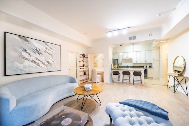 3225 Turtle Creek Blvd Unit 206, Dallas, TX 75219 - living room featuring track lighting, ornamental molding, and light wood-style floors