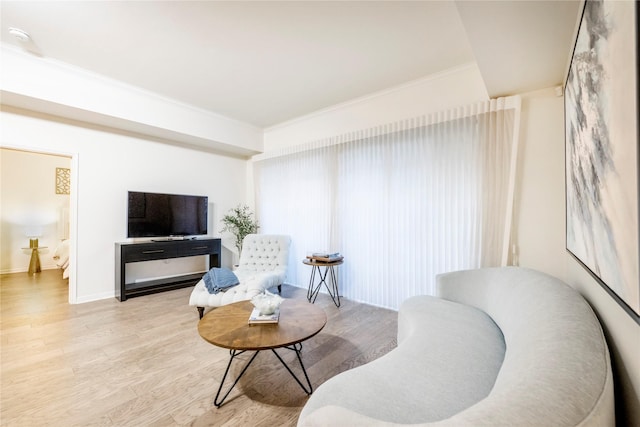 sitting room featuring crown molding, wood finished floors, and baseboards