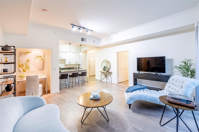 3225 Turtle Creek Blvd Unit 206, Dallas, TX 75219 - living area with light wood finished floors, rail lighting, ornamental molding, and baseboards