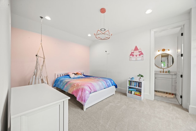 bedroom with connected bathroom, light carpet, a sink, and recessed lighting
