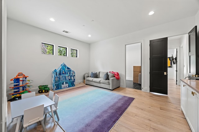 living area with recessed lighting, light wood-type flooring, and visible vents