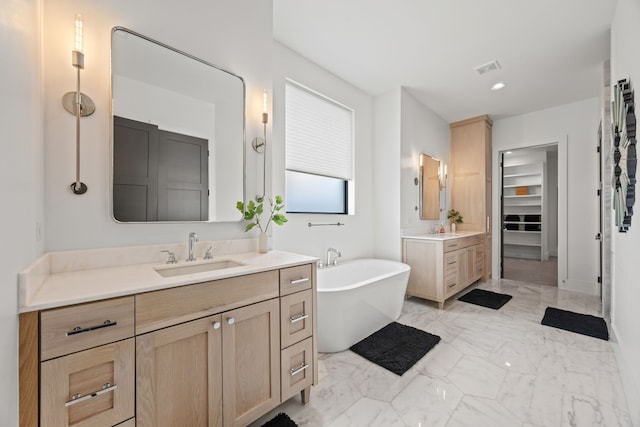 bathroom featuring two vanities, a soaking tub, marble finish floor, and a sink