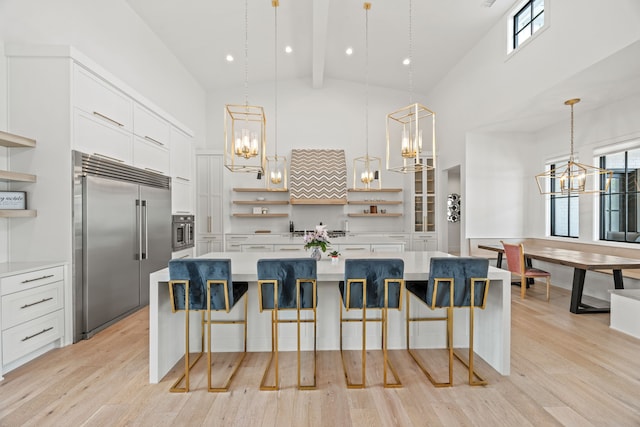 kitchen featuring open shelves, an inviting chandelier, high vaulted ceiling, and built in refrigerator