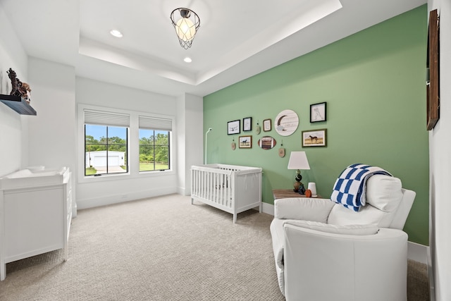 bedroom with a nursery area, carpet floors, a tray ceiling, baseboards, and recessed lighting