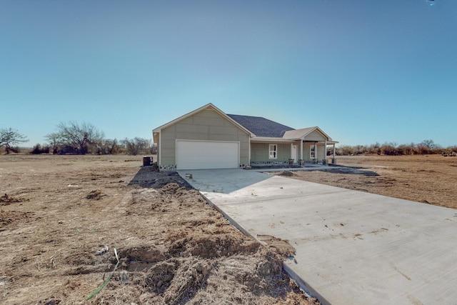 ranch-style home featuring a garage, covered porch, and driveway
