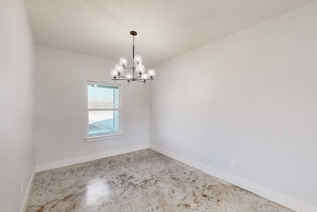 empty room featuring a chandelier and baseboards
