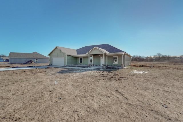 view of front of property with covered porch, an attached garage, and driveway