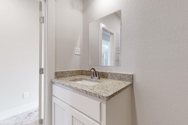 bathroom with vanity and a textured wall