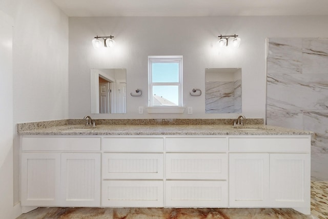 bathroom featuring double vanity and a marble finish shower