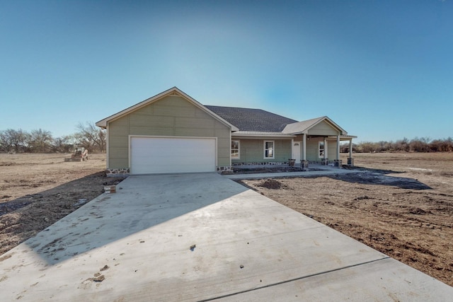 ranch-style home featuring a porch, a garage, and concrete driveway
