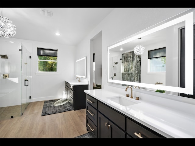 612 Glade Stream Ct, Azle, TX 76020 - bathroom with two vanities, a sink, a chandelier, wood finished floors, and a shower stall