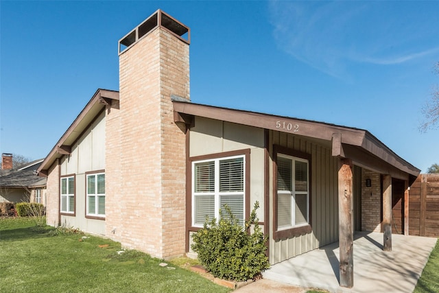 5102 Galaxie Rd, Garland, TX 75044 - view of home's exterior featuring a chimney, a lawn, board and batten siding, and brick siding