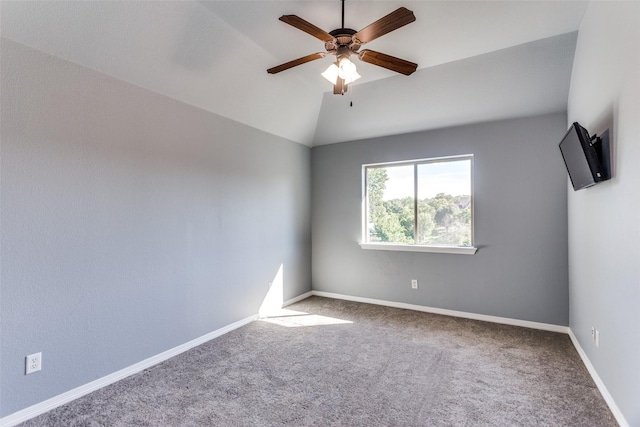 carpeted spare room featuring ceiling fan, lofted ceiling, and baseboards