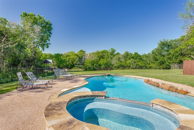 view of pool featuring a patio, a pool with connected hot tub, and view of wooded area
