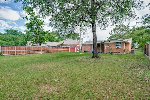 view of yard featuring a fenced backyard, an outbuilding, and a shed