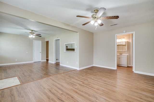 unfurnished room with light wood-type flooring, baseboards, a ceiling fan, and visible vents