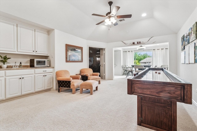 rec room featuring ceiling fan, light carpet, vaulted ceiling, and a sink