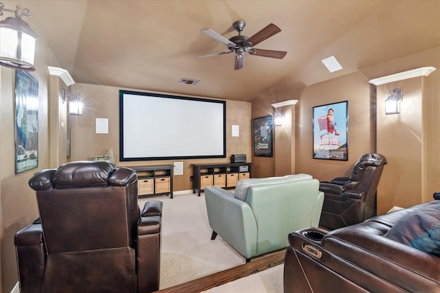 carpeted cinema room with lofted ceiling, visible vents, baseboards, and ceiling fan