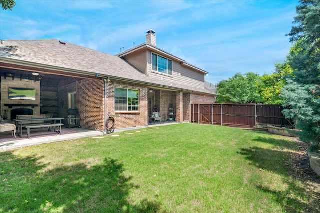 back of property featuring fence, a lawn, a patio area, and brick siding