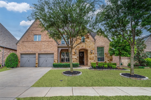 traditional-style house featuring a front lawn, concrete driveway, stone siding, brick siding, and a garage