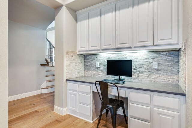 office area with baseboards, built in study area, and light wood-style floors