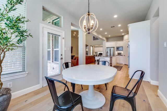 dining room featuring recessed lighting, light wood-style flooring, plenty of natural light, and an inviting chandelier